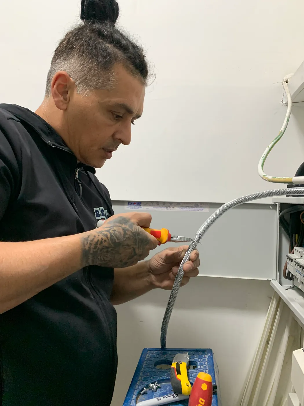 BS4 electrician preparing cable for a new circuit