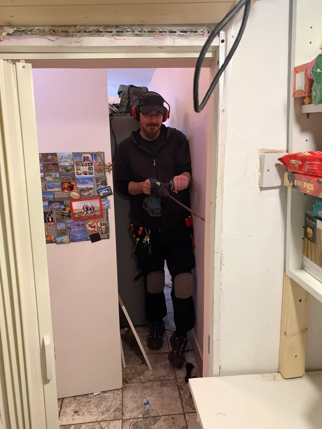 BS4 electrician drilling in a utility room