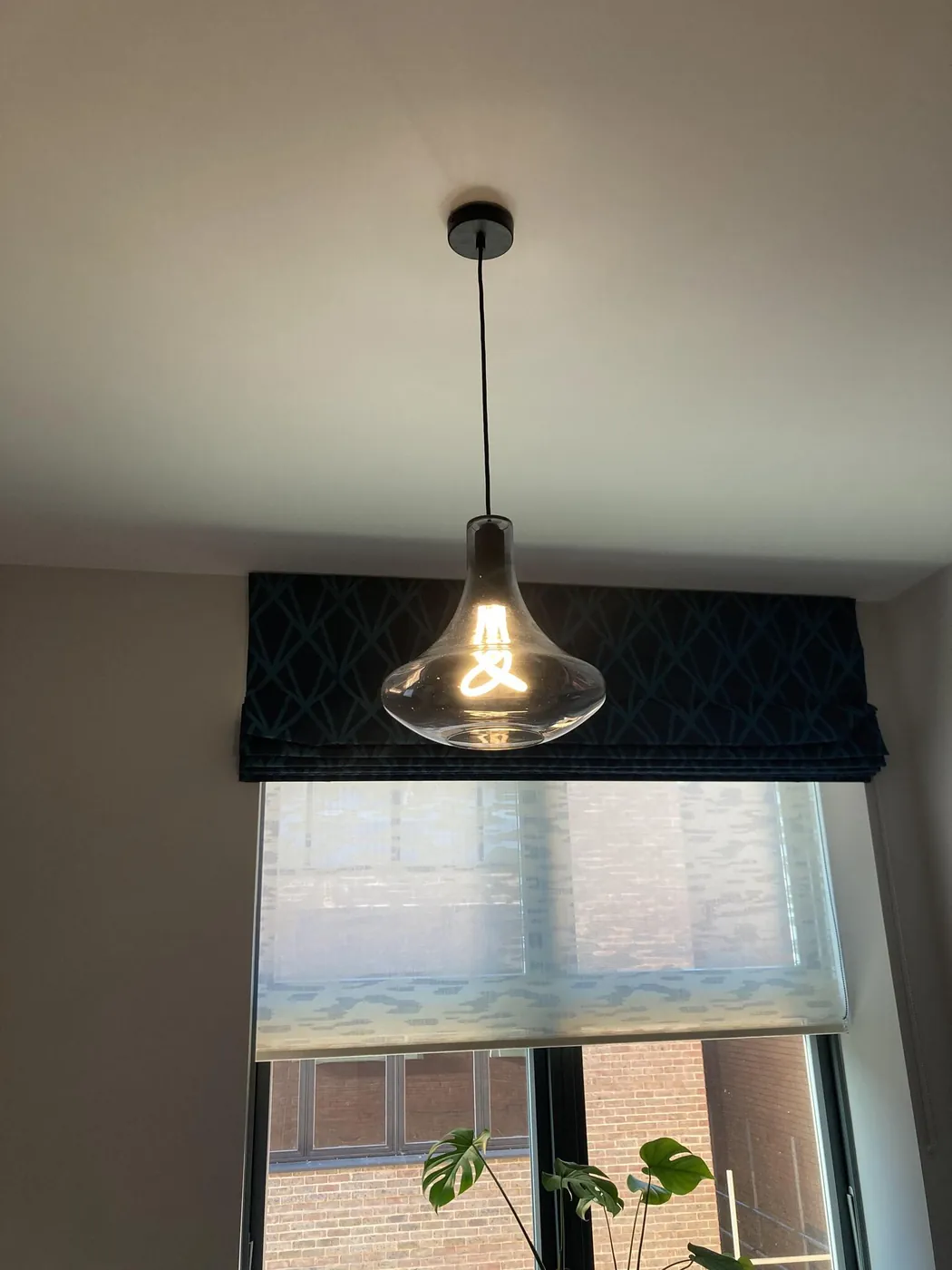 Glass pendant light fitted above a window